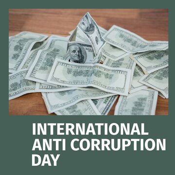 Image of international anti corruption day over dollar banknotes lying on table