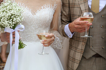 The bride and groom drink champagne at the wedding.