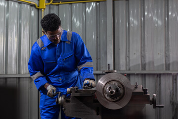 Engineering worker man African American wearing uniform safety working machine lathe metal brake...