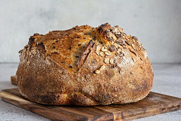 Fresh homemade bread (slice) from whole grain sourdough flour with the addition of bran, seeds (sunflower, pumpkin, flax, sesame) and oatmeal flakes. Healthy food. High quality photo.