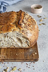 Fresh homemade bread (slice) from whole grain sourdough flour with the addition of bran, seeds (sunflower, pumpkin, flax, sesame) and oatmeal flakes. Healthy food. High quality photo.