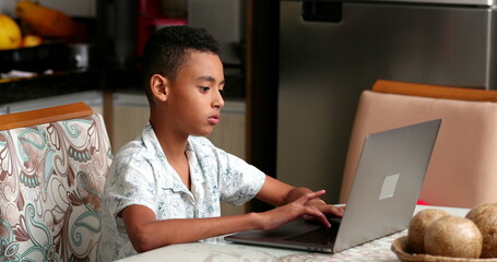Hispanic boy typing on laptop. South american child using computer for study