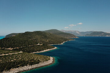 Seascape and sandy beach with turquoise clear waters and trees in Greece