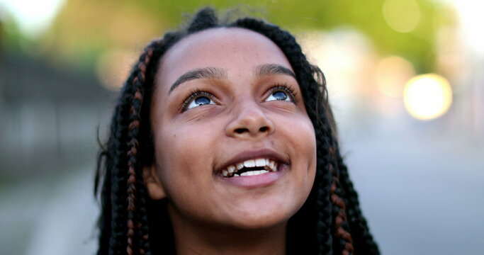 Happy black preteen girl child face smiling and looking up to sky