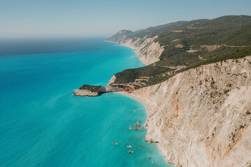 Fototapeta na wymiar Seascape and sandy beach with turquoise clear waters and trees in Greece