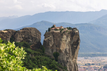 Fototapeta na wymiar The size of this rock plateau allowed the monks to create not only religious buildings but also a wonderful lawn, plant trees and flowers, and admire the view, St. Stephen Monastery, Meteora, Greece.