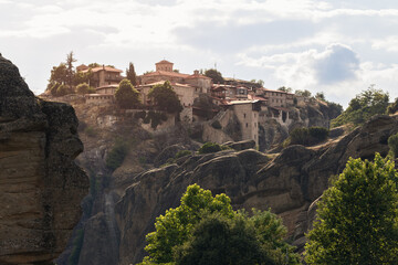 Holy Monastery of Great Meteoron complex on top of steep rock bathed in evening light. One of Meteora's historic gems and popular religious pilgrimage destination in Greece