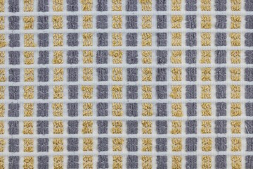 Closeup shot of a yellow gray square patterned fabric textile surface