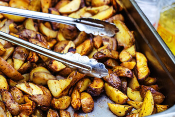 Baked potatoes on a metal baking sheet. Cooking vegetables in the oven. Close-up. selective focus