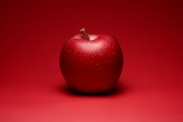 Red apple on bright red background