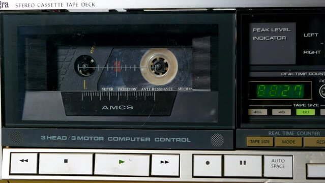 A man presses the play button on a cassette deck. Playing a vintage audio cassette.
