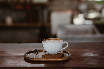 Latte coffee mugs on wooden table in a cafe, beautiful with natural light, vintage tones, food and drink.