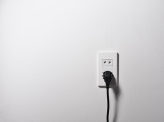 electrical socket and electrically cable on a white wall