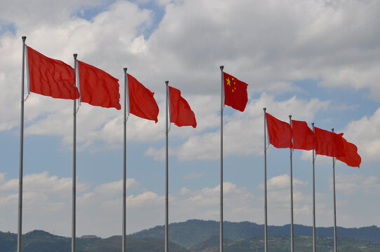 row of red chinese flags in nature