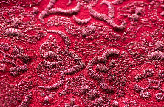 red and pink fabric texture background with embroided pattern