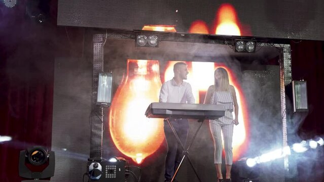 Musicians Duet performans on stage with piano and background interactive board