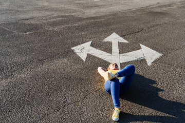 Woman relaxing near three way direction arrow sign on road