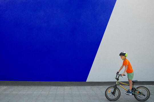 Boy Doing BMX Cycling By Two Toned Wall