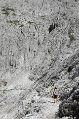 Young woman walks on the trail of the Dolomites in the European Alps called Pale Group  in Italy