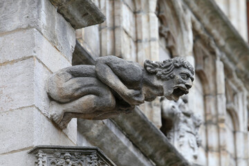 Fototapeta premium Monstrous statue with almost human features called gargoyle on the historic building