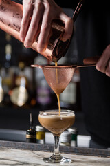 Fototapeta na wymiar bartender pouring cocktail into glass