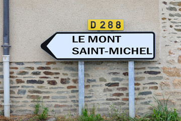 road sign with the text Mont St Michel and the arrow to reach the Normadian abbey in France