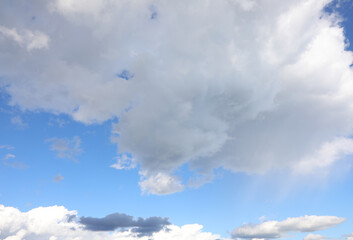 clear blue sky with white clouds and some black clouds