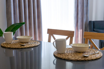 Obraz na płótnie Canvas Table set for breakfast for two people with cutlery set in a lighted space