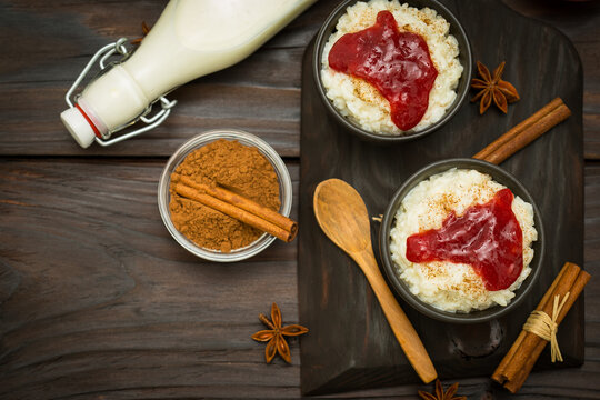 Rice pudding with cinnamon and strawberry jam on  the wooden background