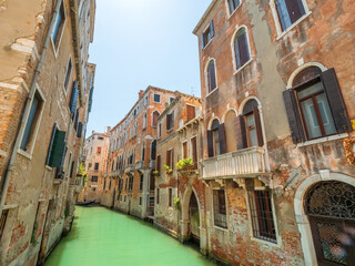 Fototapeta na wymiar Venezia Wall Architecture along the crystal clear water canal during summer time