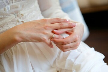 Women's hands of the bride in a wedding dress with an engagement ring on her finger. Jewelry for the bride.