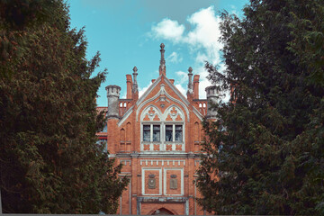 The facade of Lentvario Manor (Tiskeviciaus Manor) among the trees (foreground blurred)                        