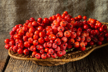 Red mountain ash in a basket on a wooden table