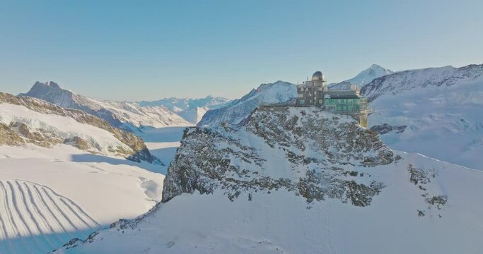 Aerial drone fly over Sphinx observatory and Aletsch glacier on Jungfraujoch, Swiss Alps, Switzerland. Jungfrau top of europe in interlaken one of the highest mountain in the world on winter sunny day