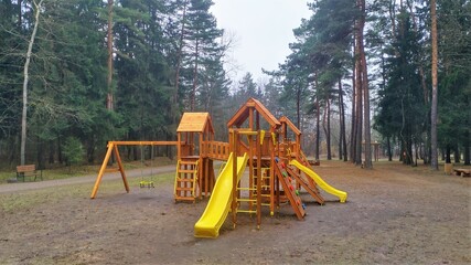 There is a playground with play structures, slides and swings in the city park among the pine trees.  Nearby there are benches for relaxing. In the fall, the weather is overcast