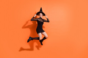 Full size photo of gorgeous girl excited jumping high discount dressed trendy black halloween garment isolated on orange color background