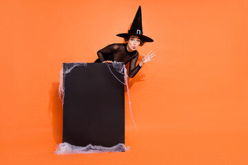 Full length photo of mystery sorcerer hand terrifying boo empty space poster isolated on orange color background