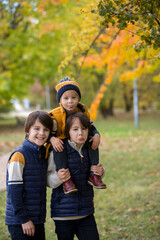Fototapeta premium Happy family, mother with children, having their autumn pictures taken in the park