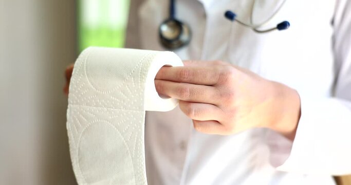 Doctor proctologist demonstrates roll of toilet paper