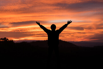 Fototapeta na wymiar man raising his arms and light in the morning