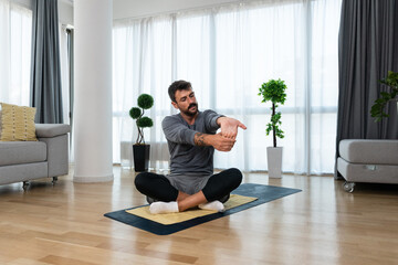 Young man cancer survivor practicing home workout yoga training, stretching muscles and breathing...