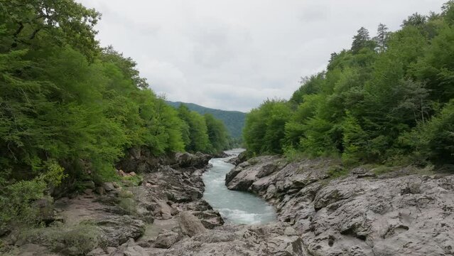 Aerial view of Mountain river and road. Flying over a mountain gorge. Slow motion video