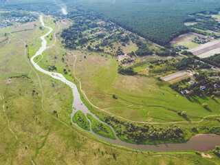Aerial view on the winding river in the meadow