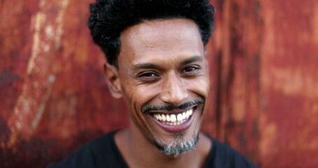 Portrait of mixed race man smiling to camera. Friendly happy african american descent person face outdoors