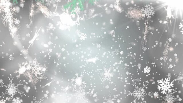 Animation of white snowflakes falling over glowing lights with green christmas tree borders