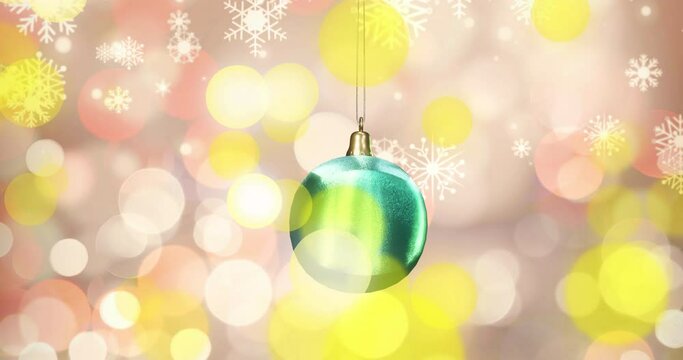 Animation of shiny blue christmas bauble with white snowflakes and yellow spots of light