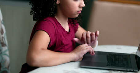 Little girl kid using laptop. Child browsing internet on computer