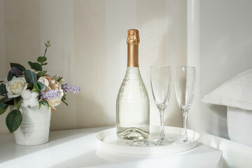 Two glasses and a bottle of champagne in a hotel room. Dating, romance, honeymoon, Valentine's day.