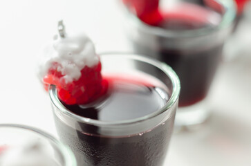 A festive red drink with a Christmas tree decoration made of raspberry and whipped cream