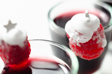 A festive red drink with a Christmas tree decoration made of raspberry and whipped cream